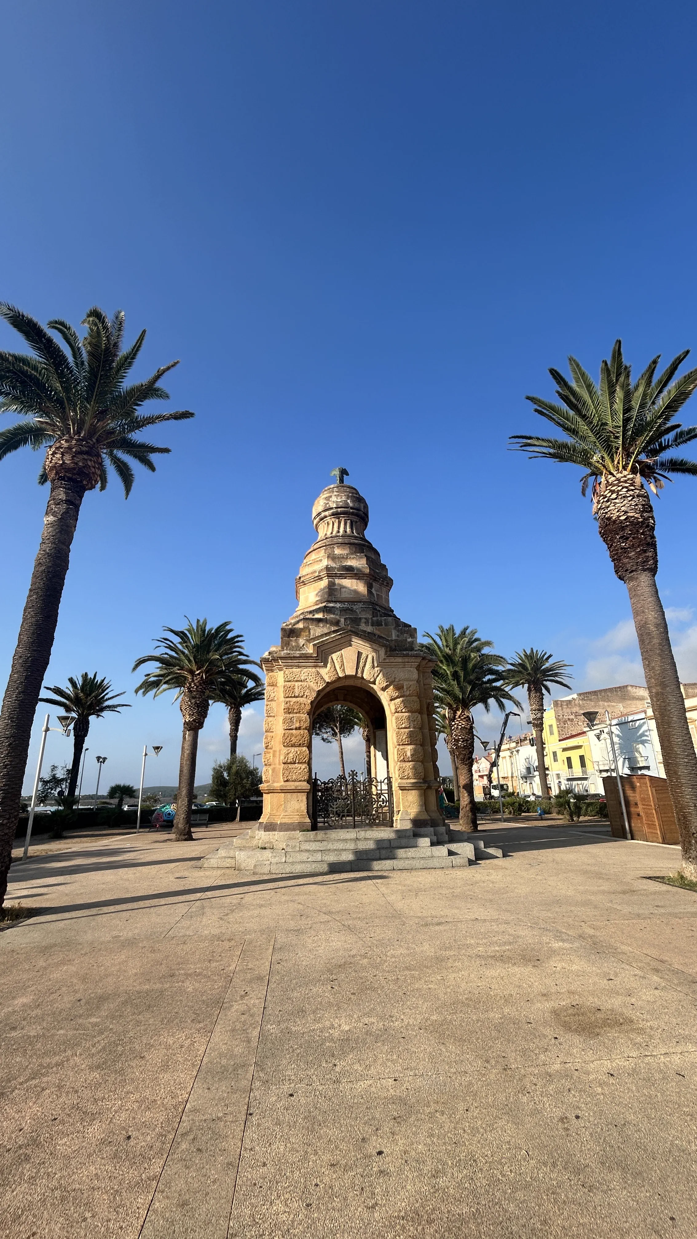 Steinernes Denkmal zwischen Palmen in Carloforte